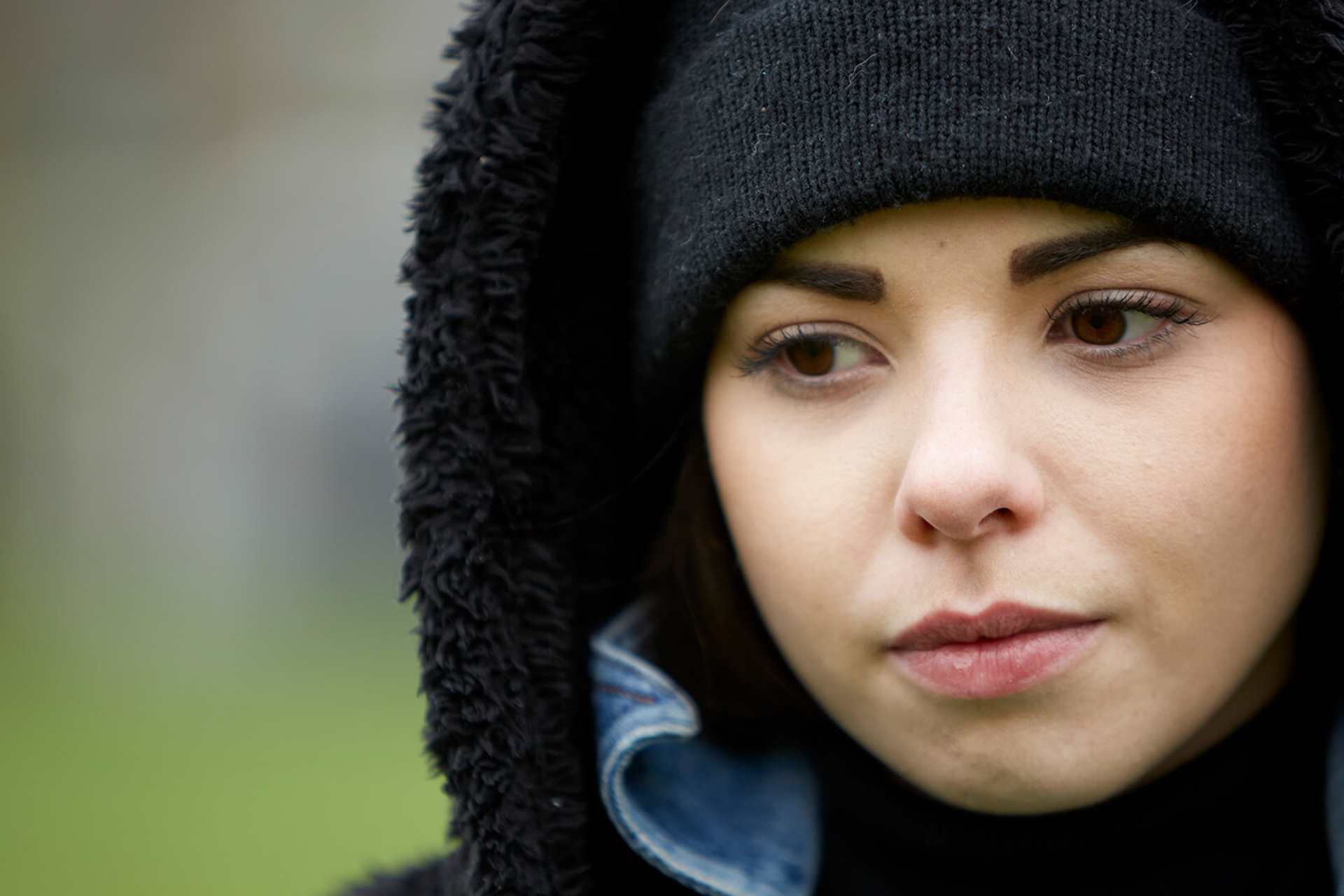 close-up-of-a-girl-wearing-black-beanie-looking-worried-with-eyes-looking-down