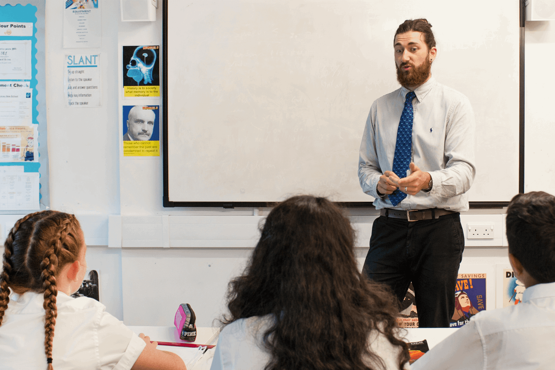 A male teacher leading a class room of students