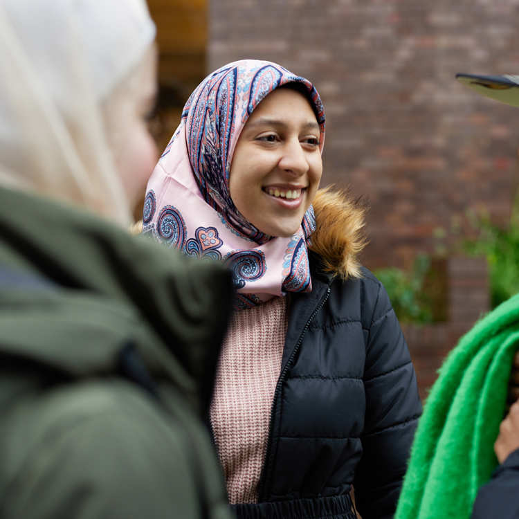 Three people chatting outside.