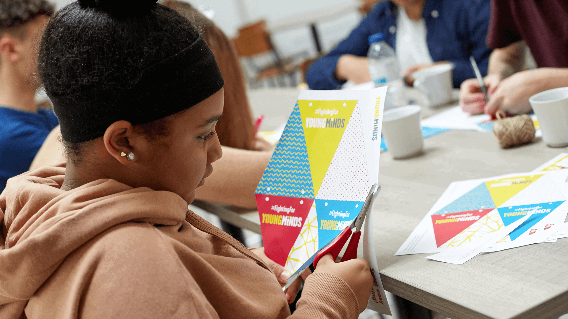 young woman cutting out YoungMinds bunding as fundraising promotional materials