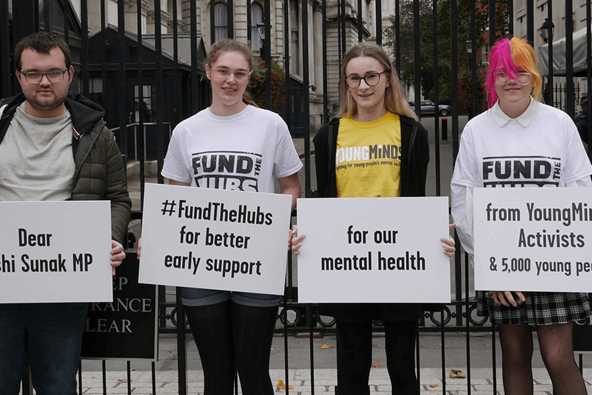 Four YoungMinds Activists at Downing Street holding placards calling for Rishi Sunak MP to Fund The Hubs