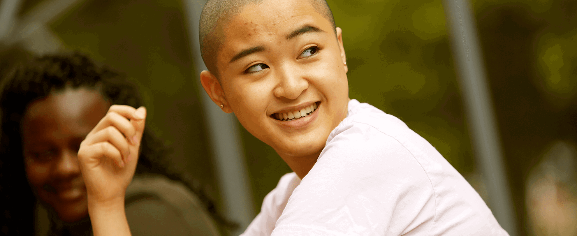 A young person smiling at their friends.