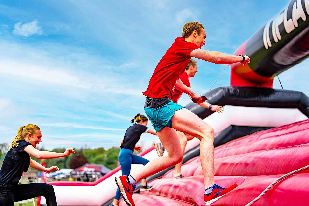 Runners climbing up an inflatable course