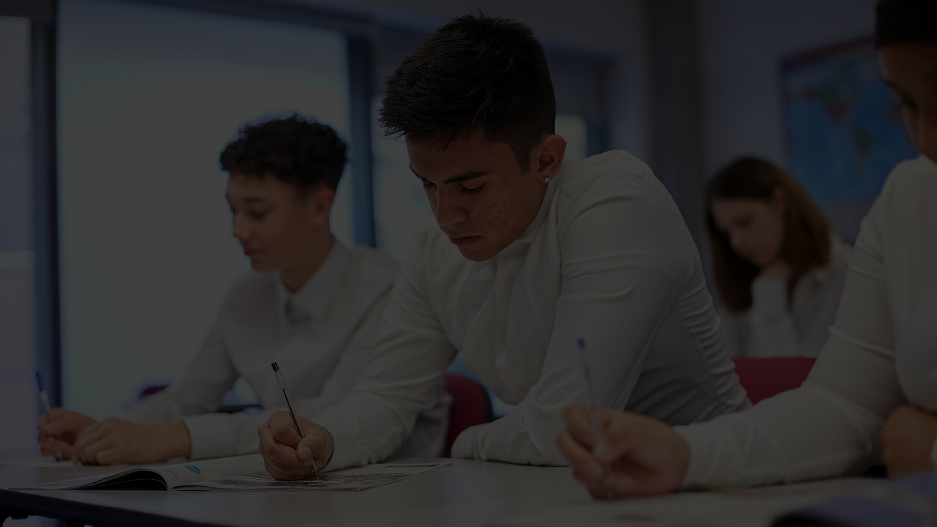 A group of young people taking an exam in school.