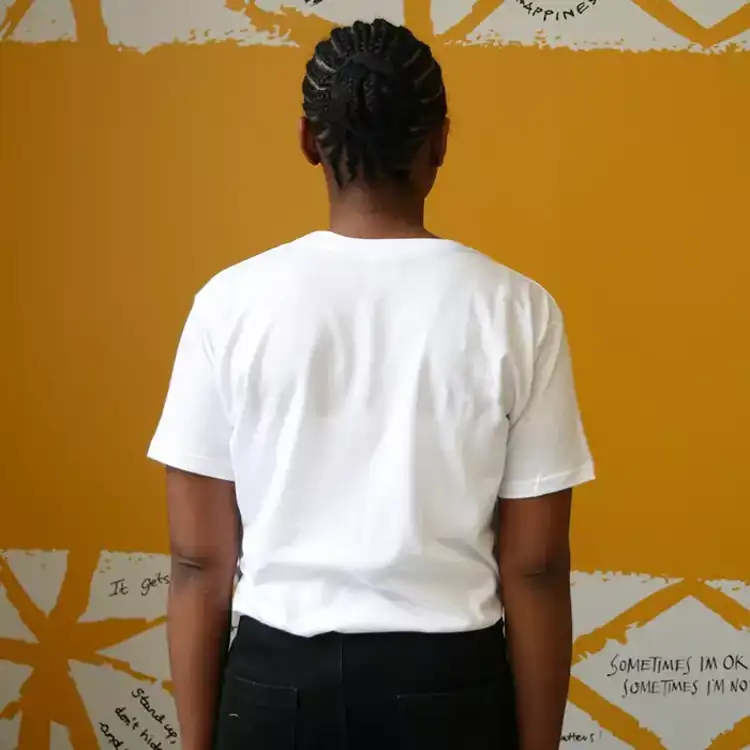 The back of a woman wearing our Nina Bombina bespoke 'You are not alone' graphic Hello Yellow T-shirt. Plain white.
