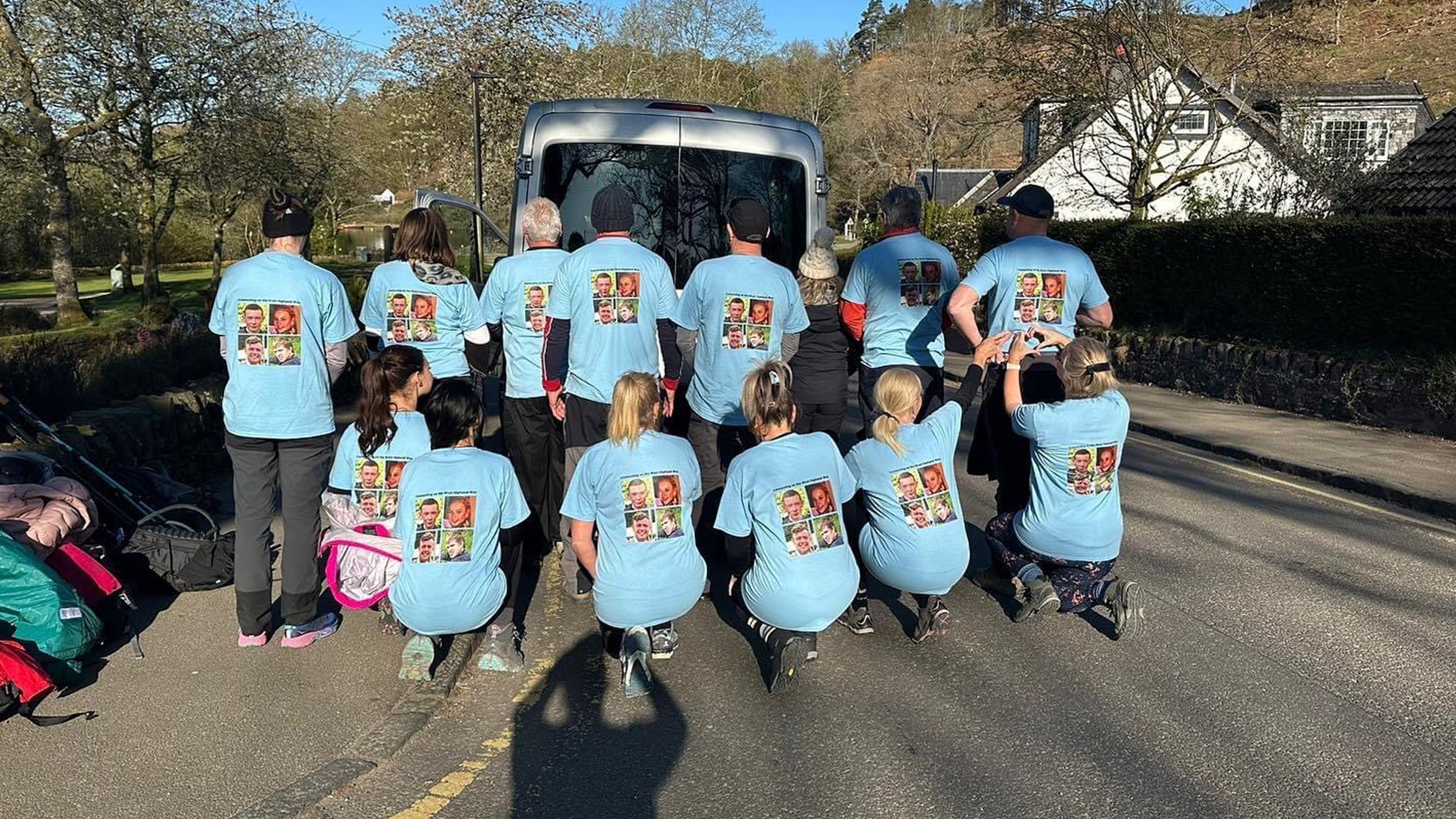 A group picture of 4 Families Walking showing the back of their t-shirts with their loved ones pictures.