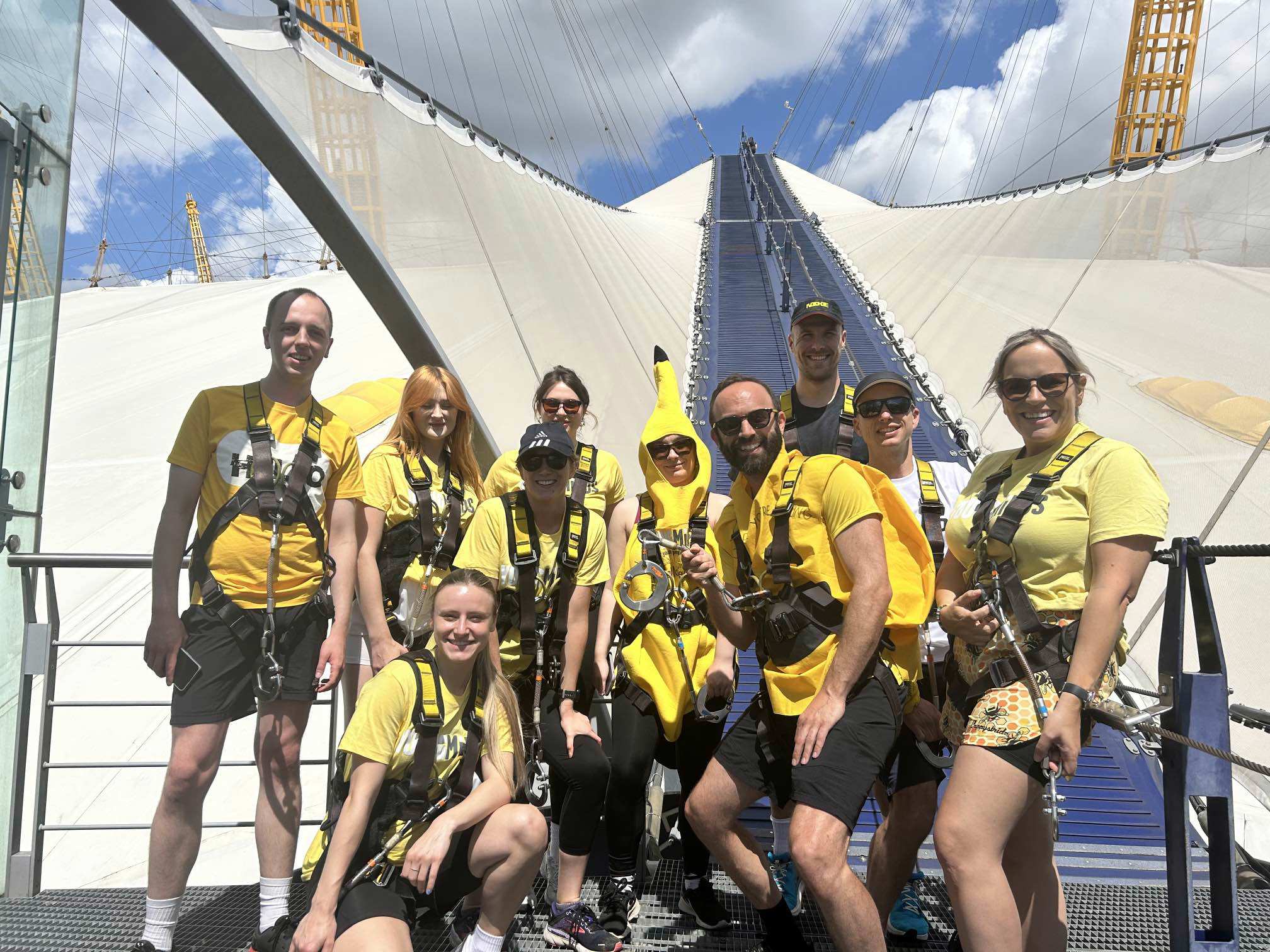 Group of people climbing the O2 building in yellow tshirts