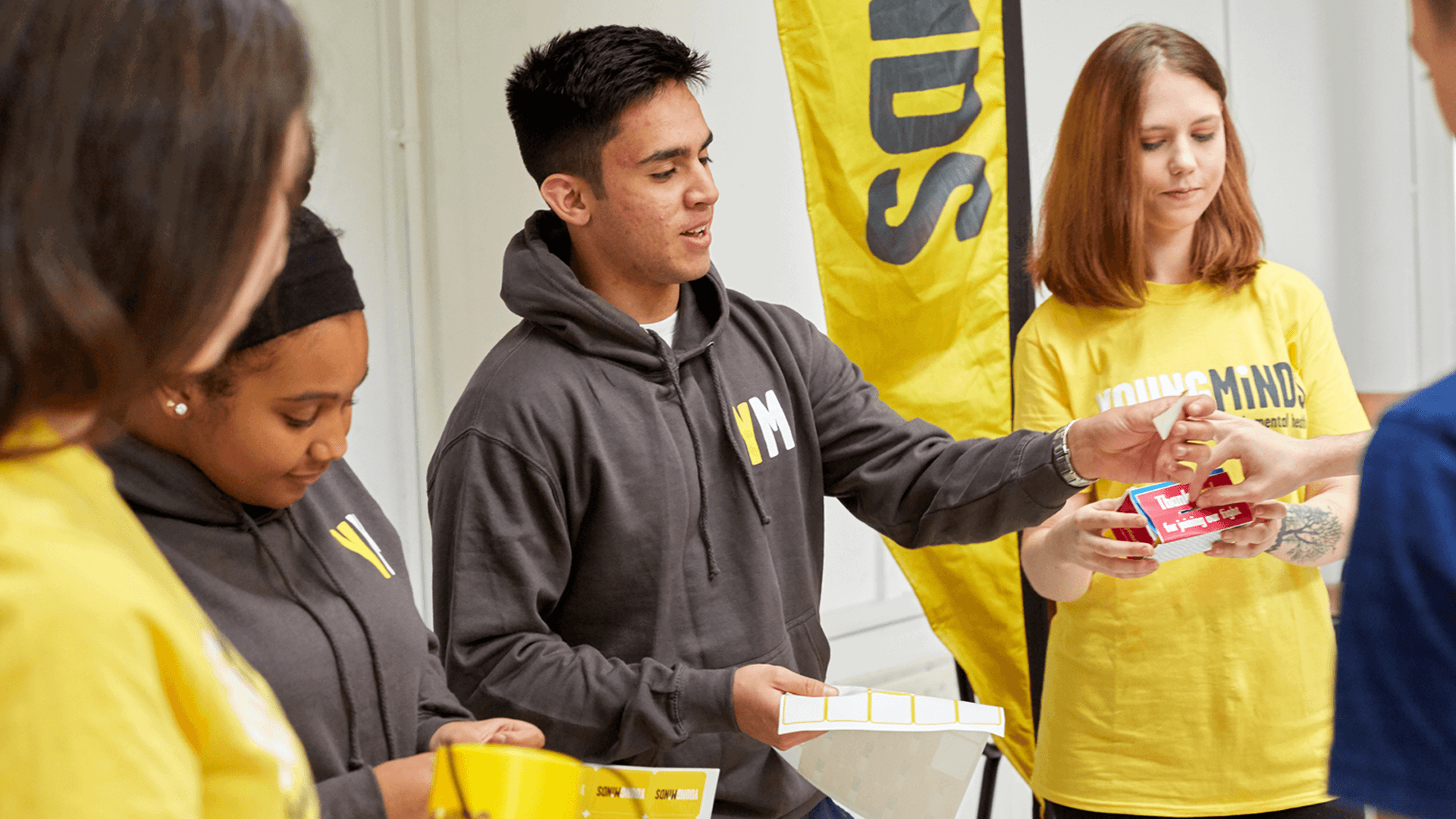 mixed group of YoungMinds volunteer giving out fundraising materials