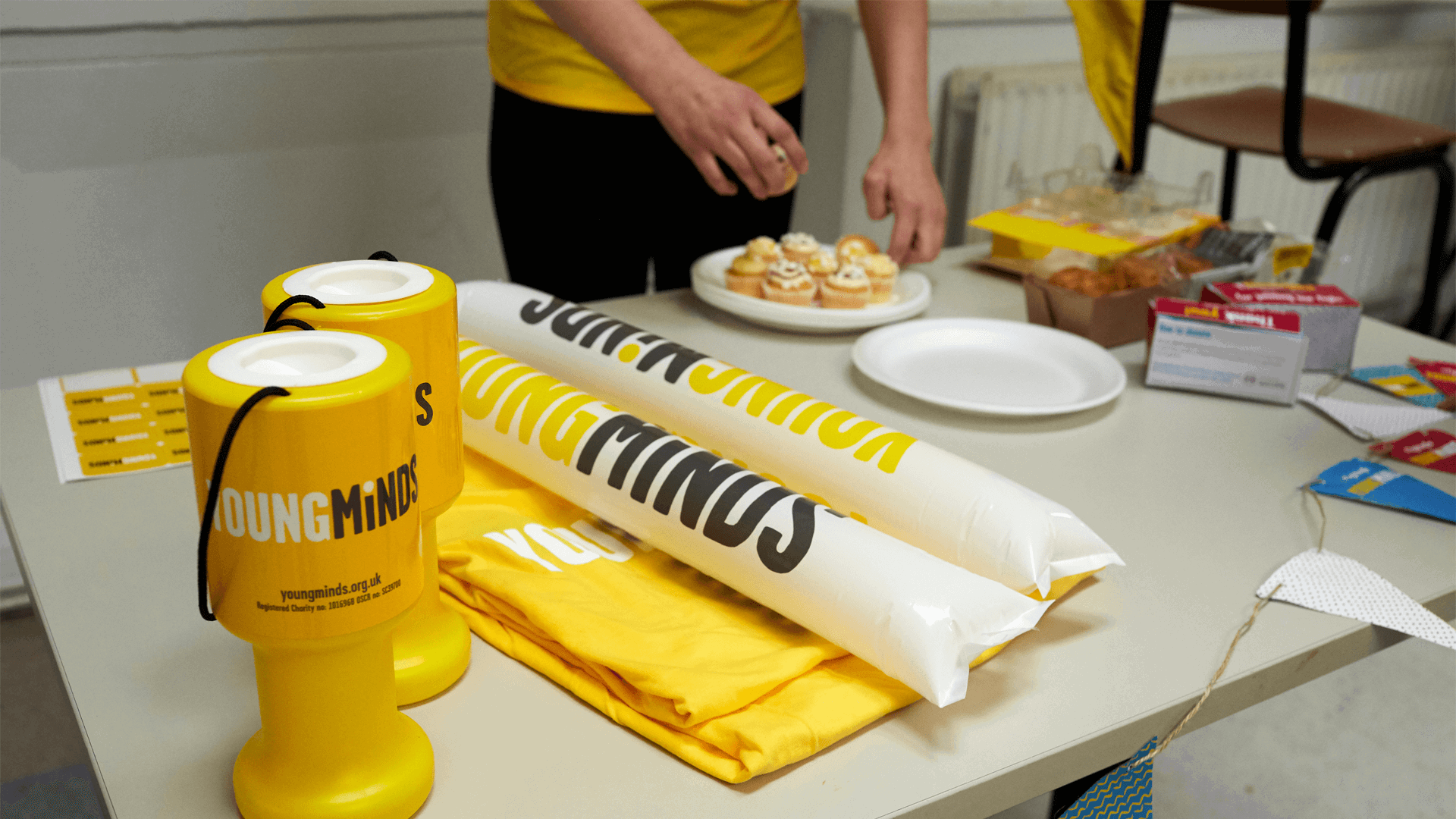 YoungMinds cheering sticks, shirts, stickers, and other fundraising materials on the table