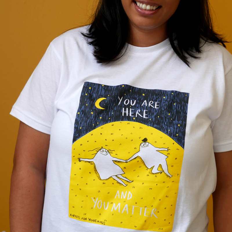 A close up of a woman smiling wearing our Rubyetc bespoke 'You are here and you matter' graphic #HelloYellow T-shirt