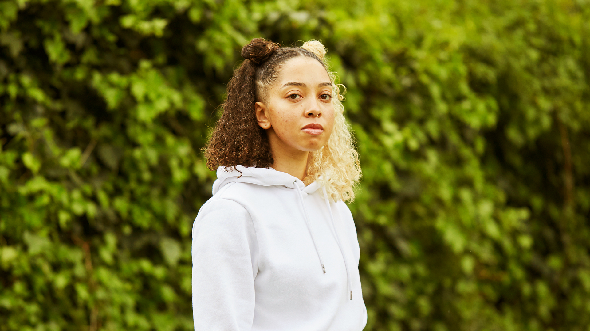 A girl starting at the camera in the park.