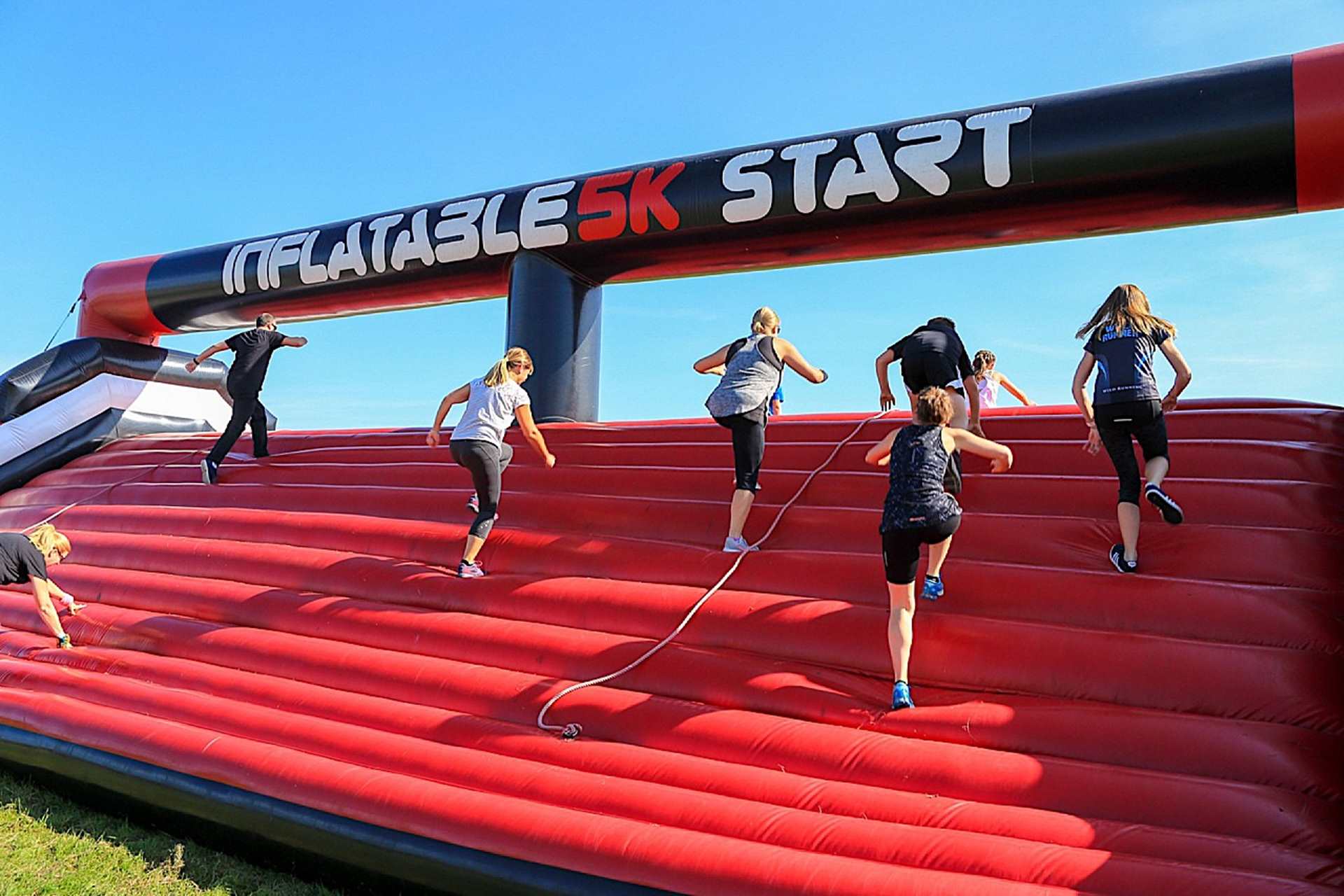 Runners climbing up an inflatable course at the start of the race