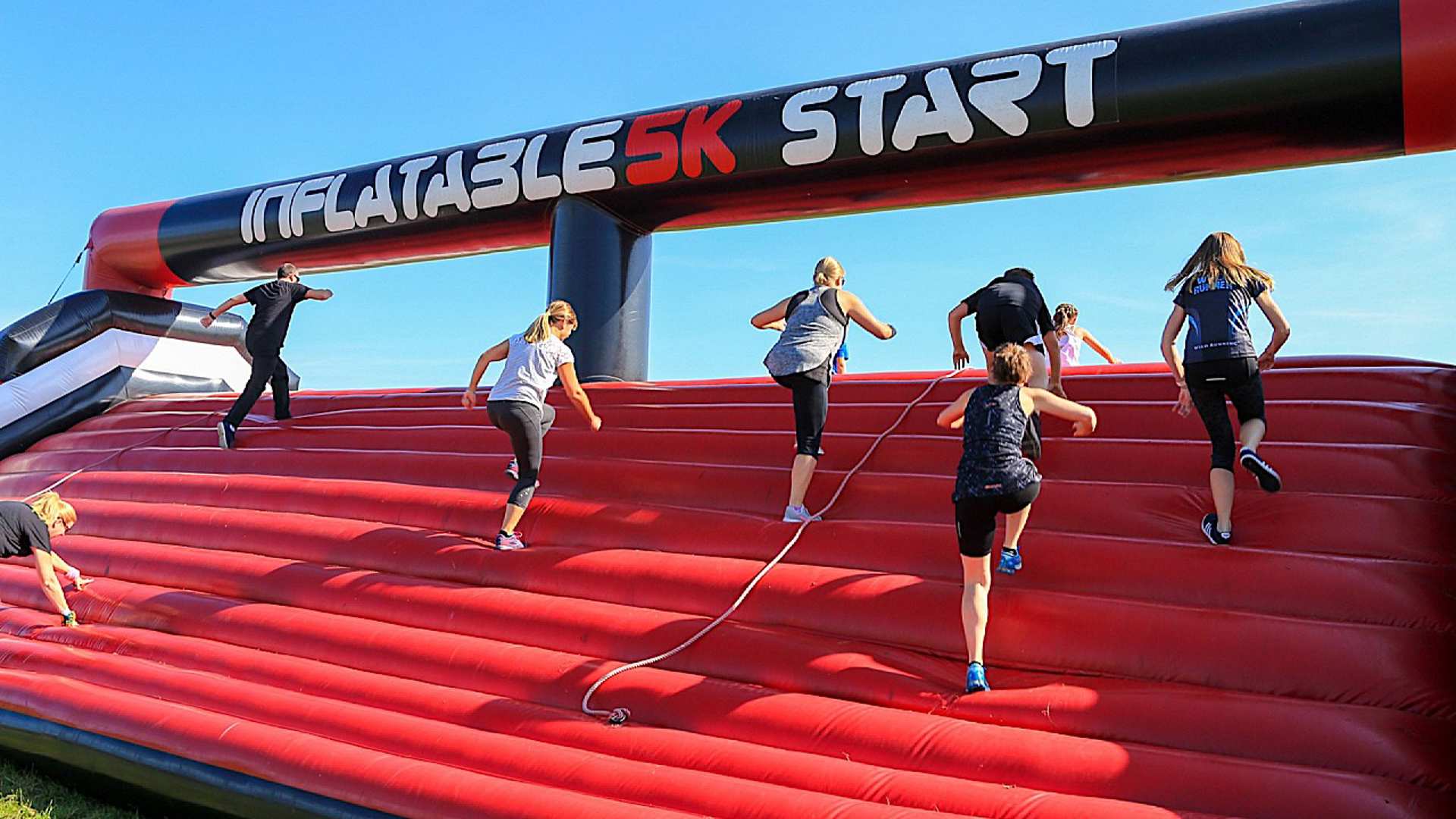 Runners climbing up an inflatable course at the start of the race
