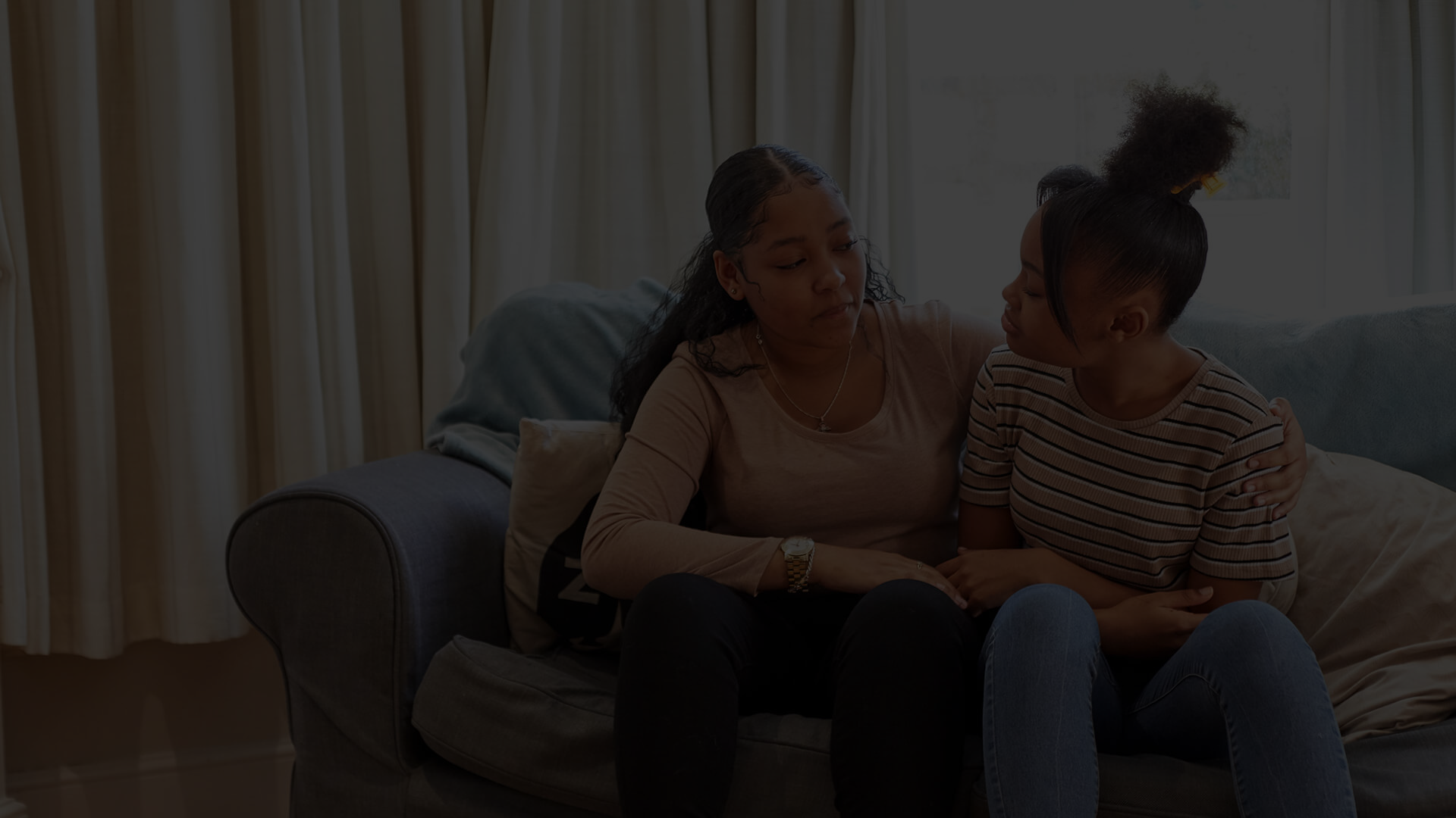 Two young people on the sofa looking upset.