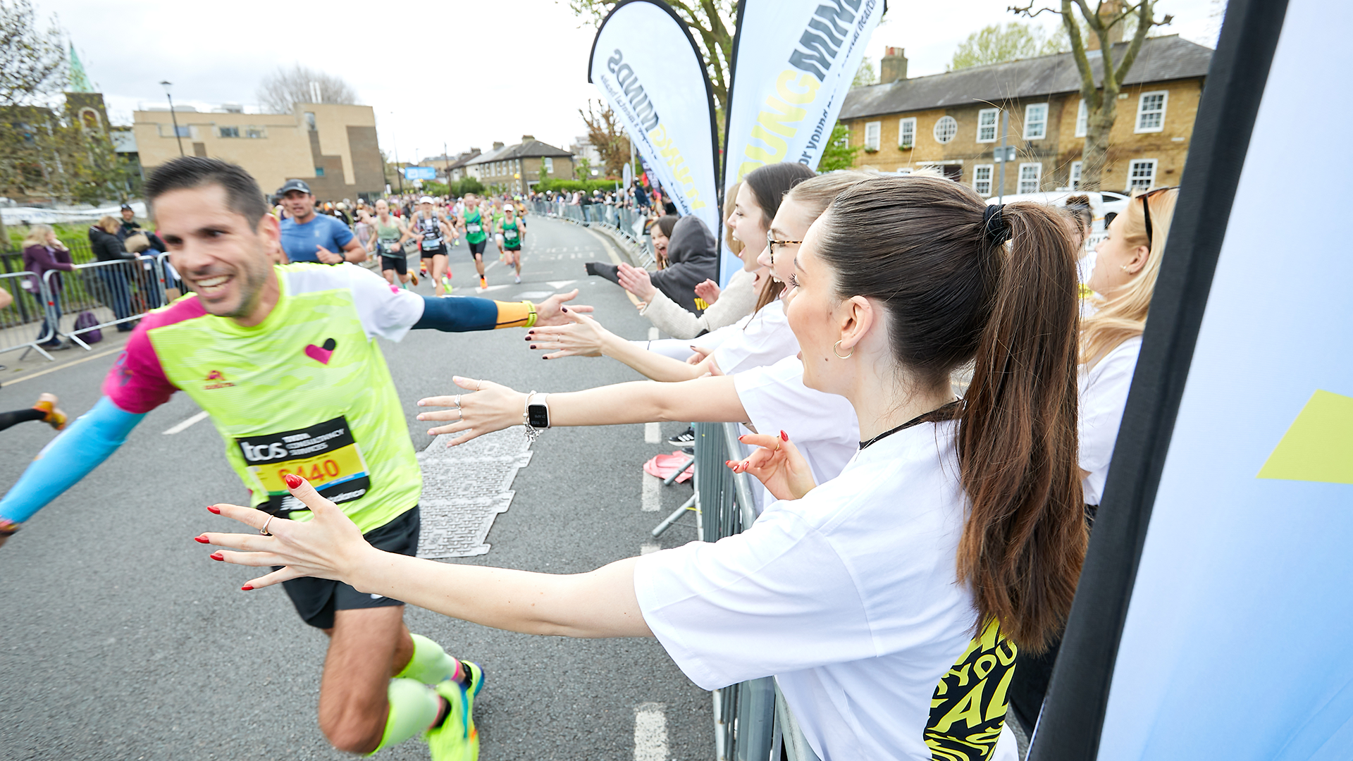 A YoungMinds marathon runner being supported by YoungMinds staff on the side line.