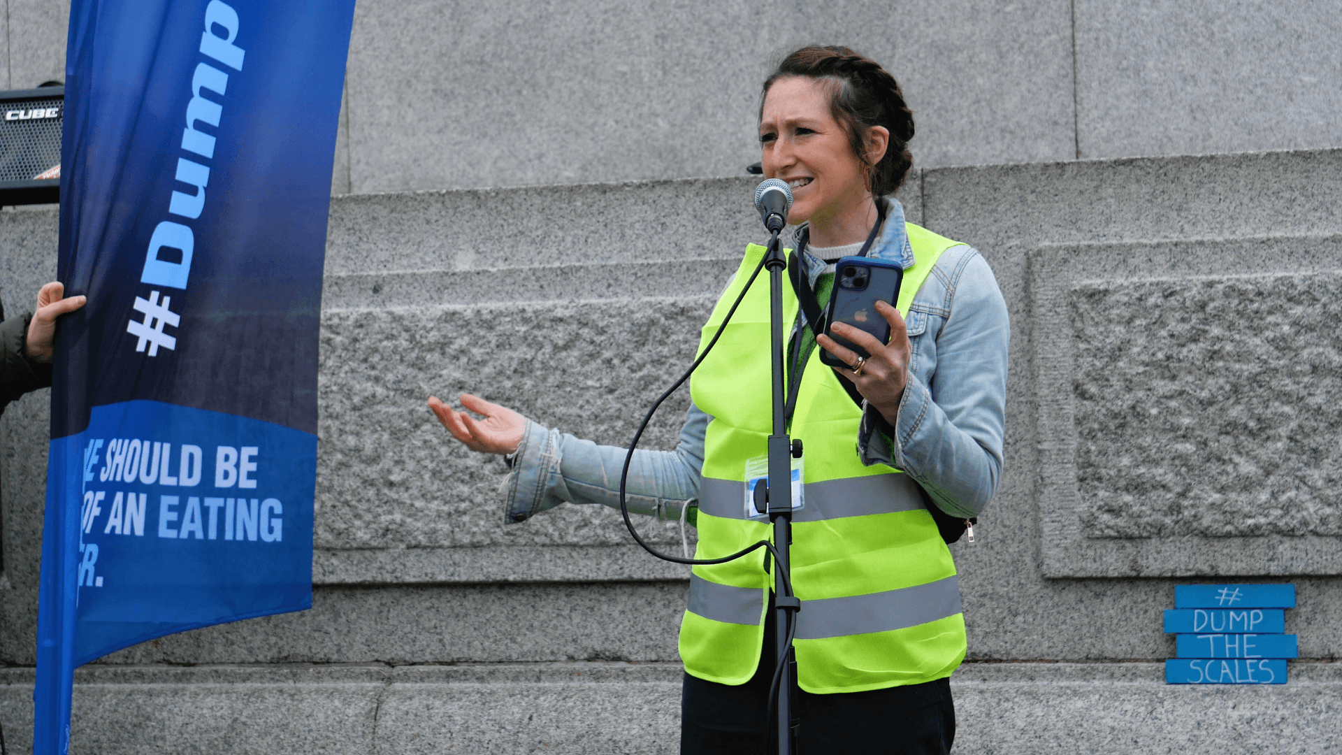 Hope Virgo speaking into a microphone at the Dump The Scales march 2024.