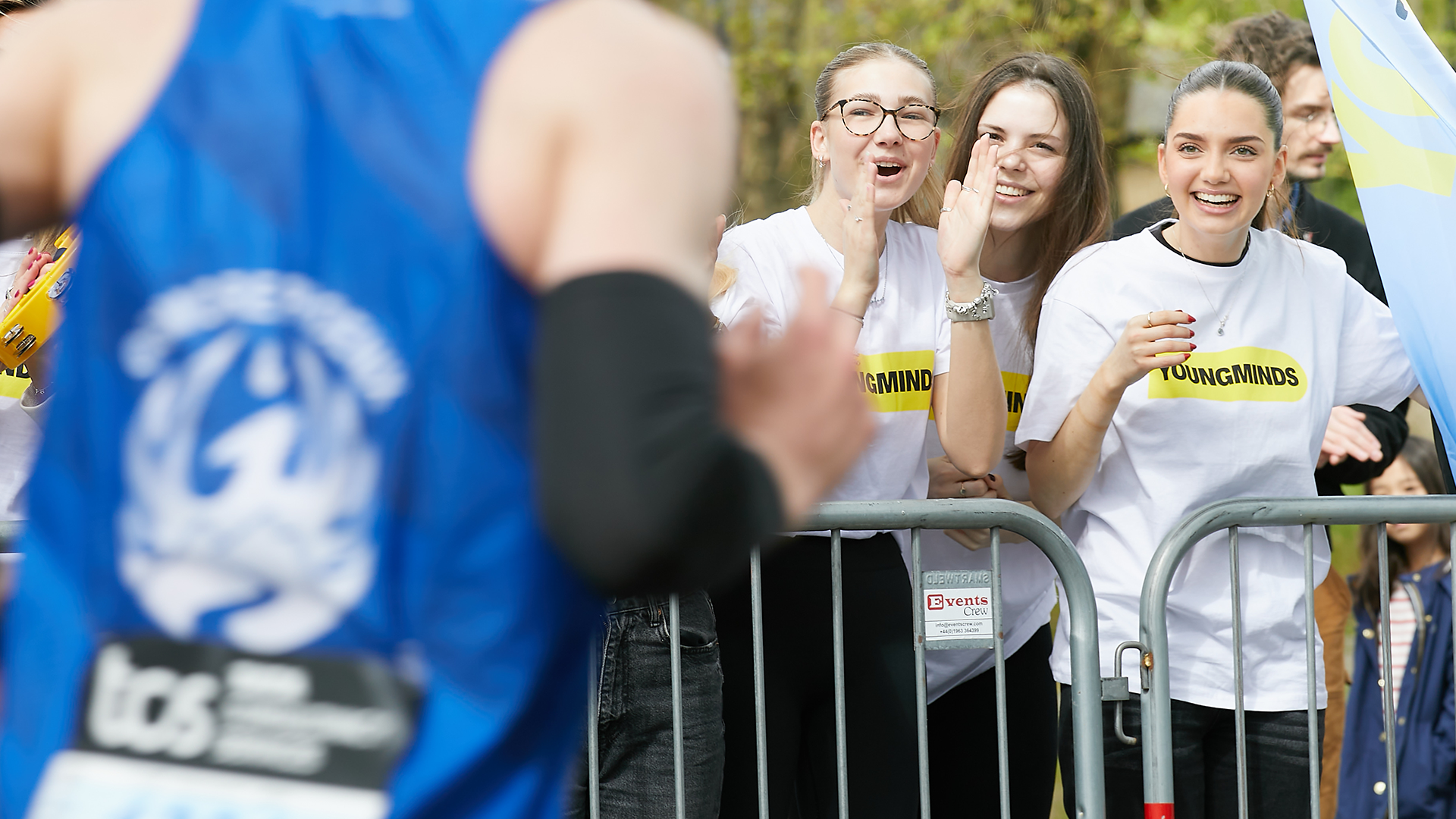 A YoungMinds marathon runner being supported by YoungMinds staff on the side line.