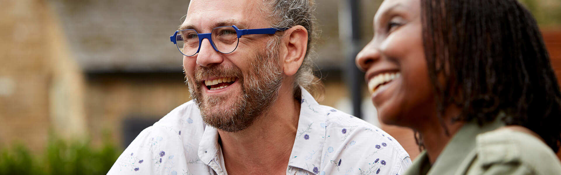 A happy couple laughing together outdoors