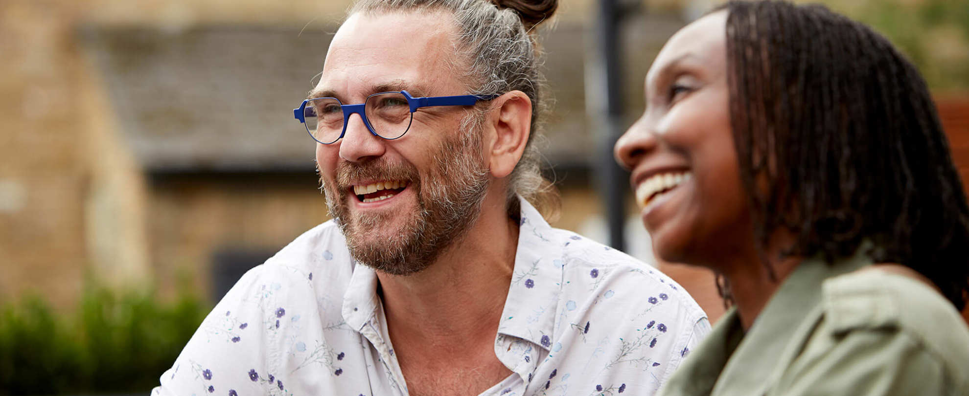 A happy couple laughing together outdoors